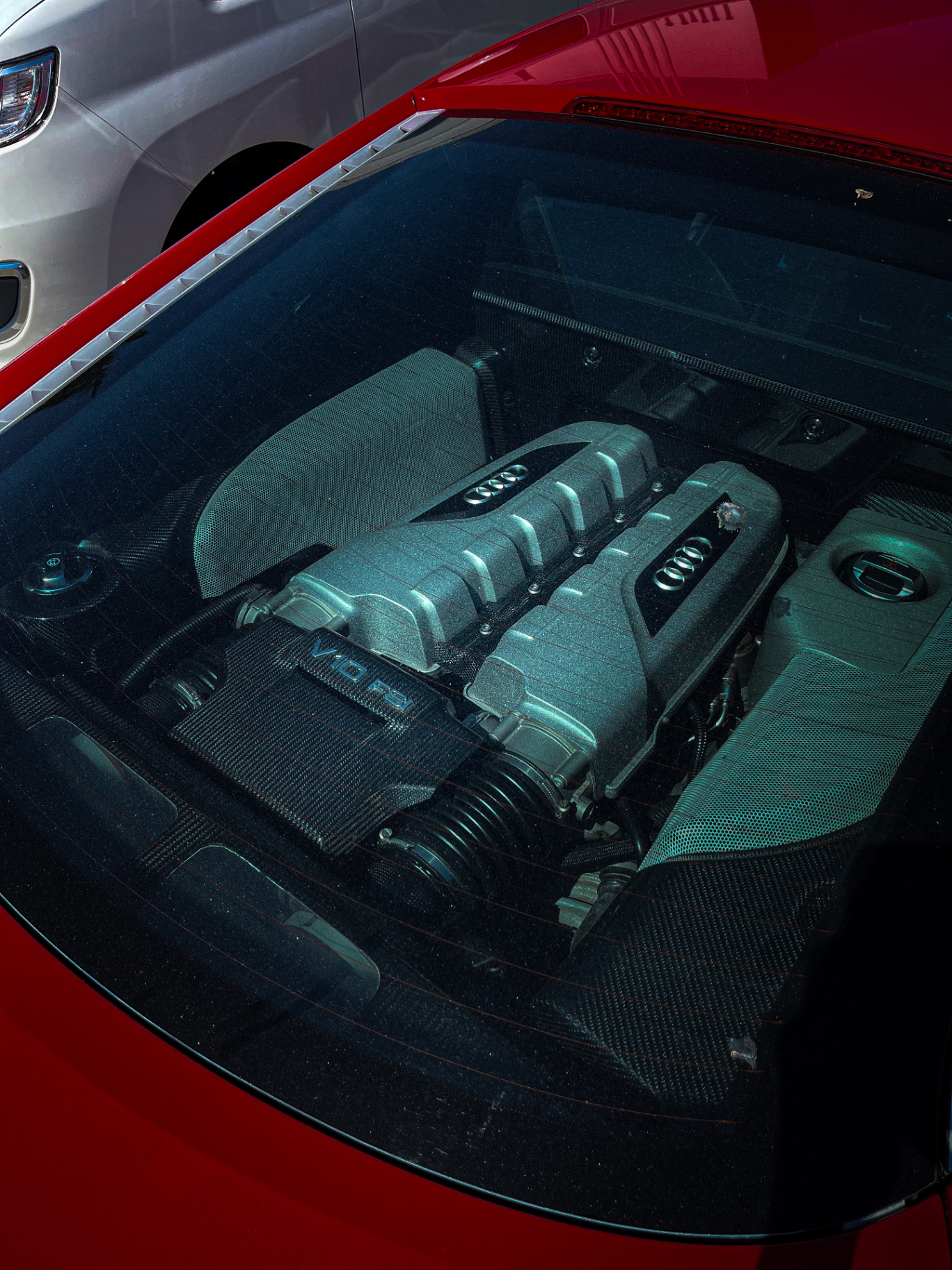 Motor V10 FSI de Audi R8 vermelho visto pelo vidro traseiro