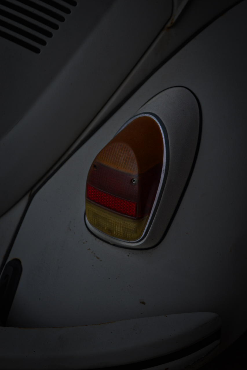 Lanterna traseira de Fusca branco em close, com vermelho e âmbar