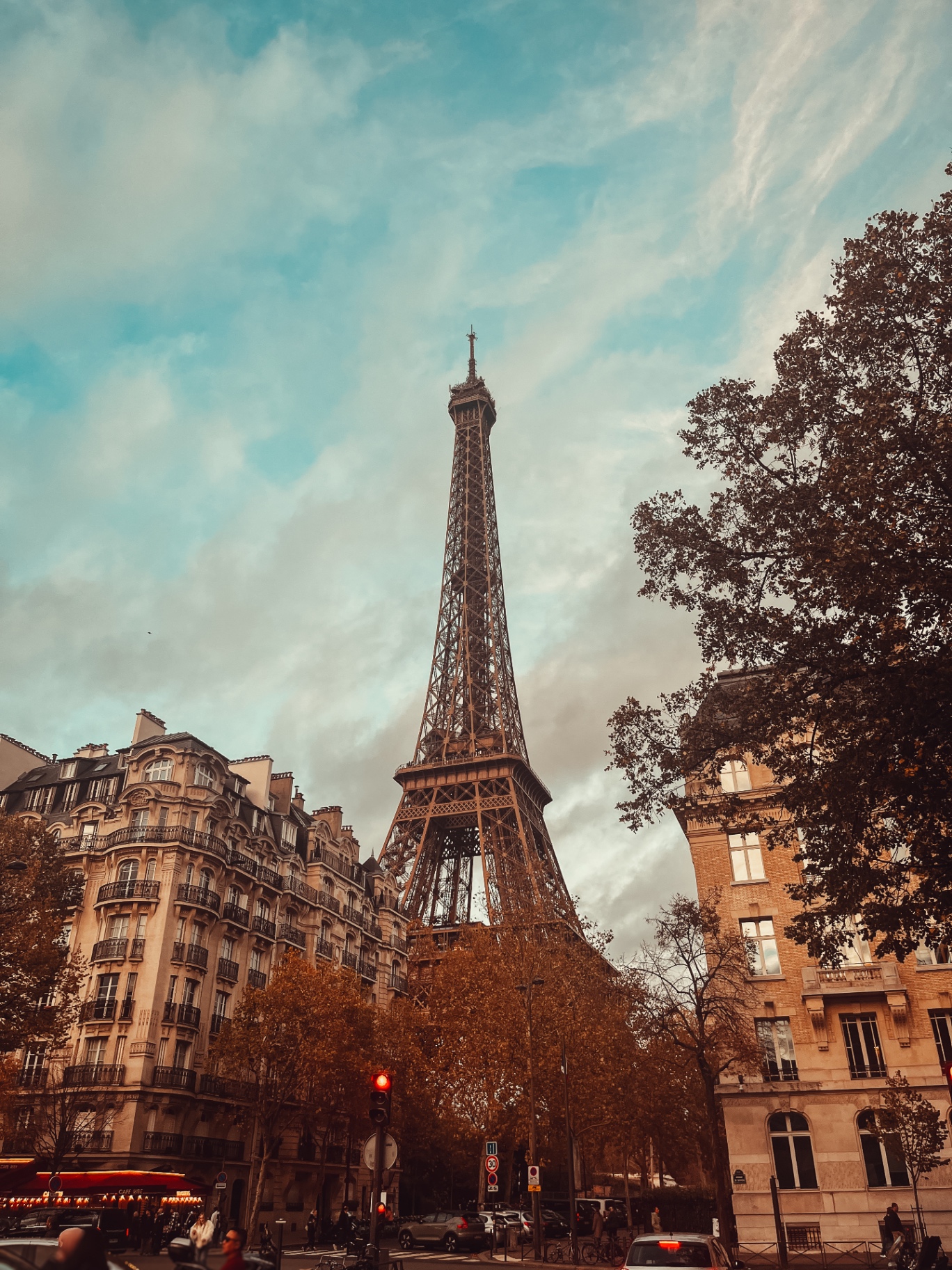 Torre Eiffel ao fundo entre edifícios haussmannianos e árvores de outono em Paris