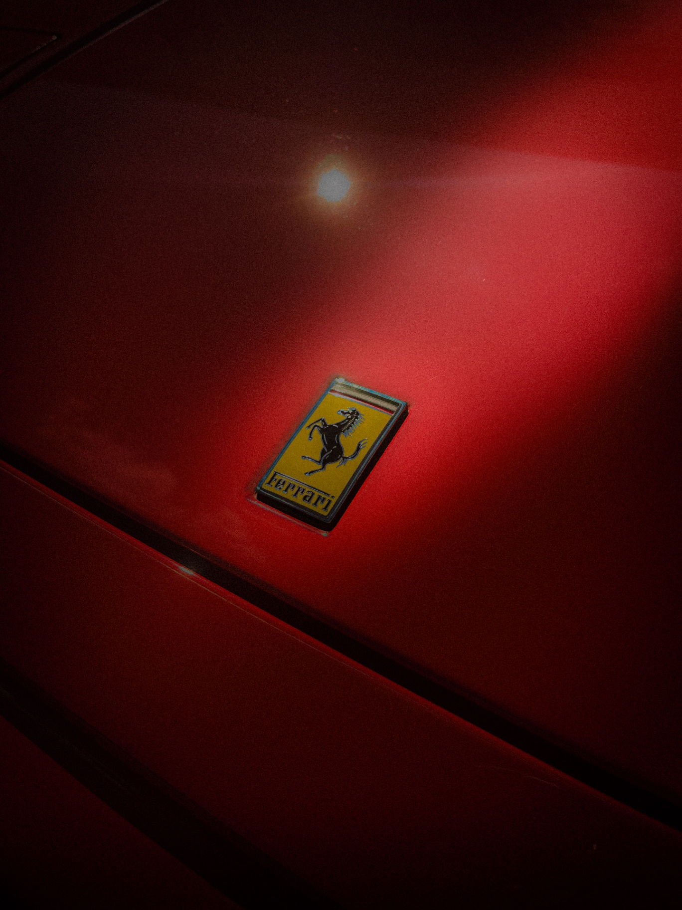 Emblema do cavallino rampante da Ferrari sobre lataria vermelha