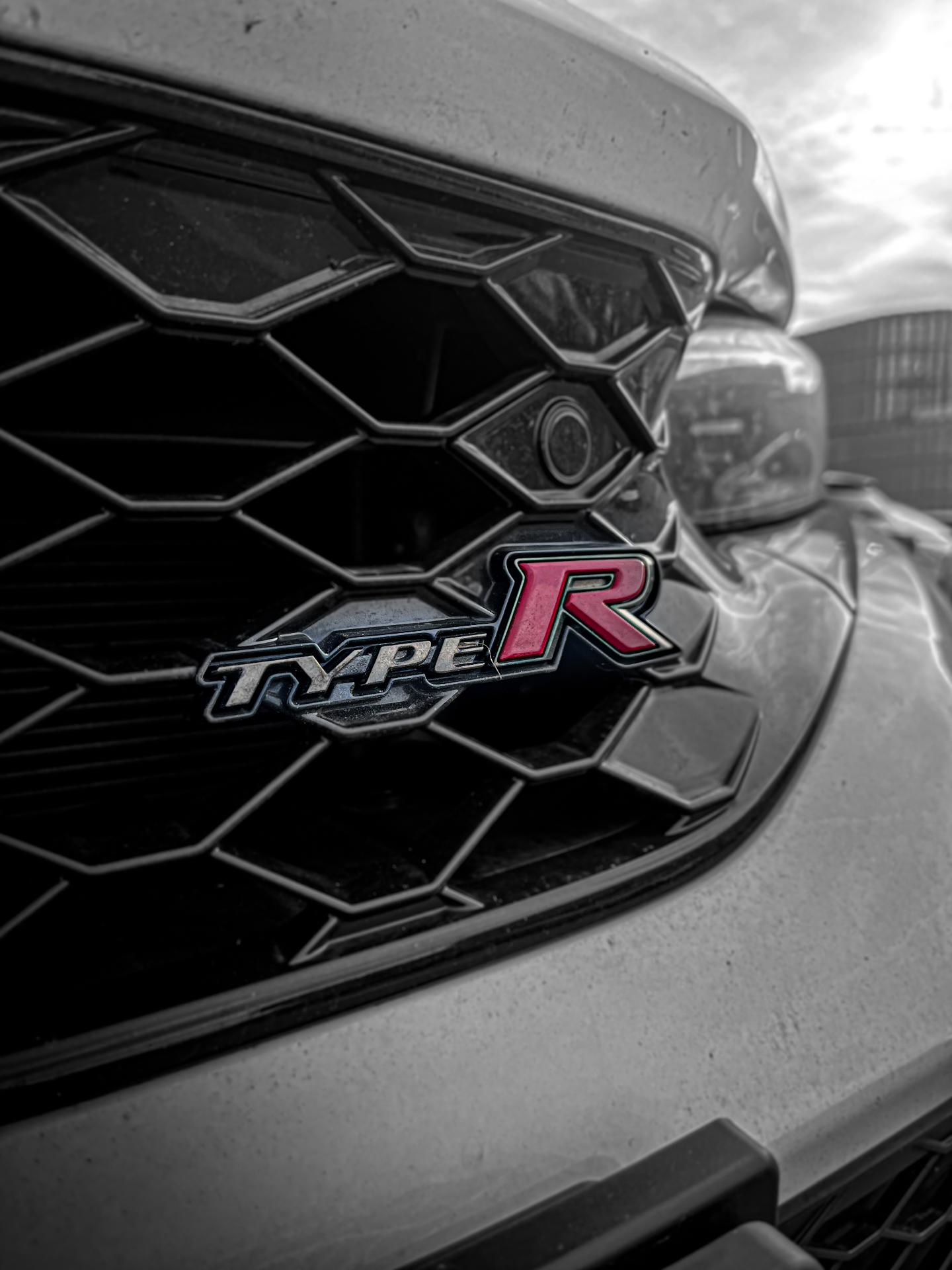 Emblema Type R em grade colmeia preta de um Honda Civic cinza